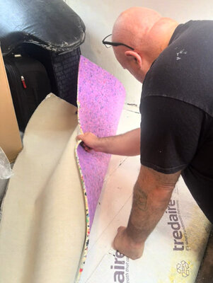 Carpet fitter laying new underlay before fitting carpet in a rental property