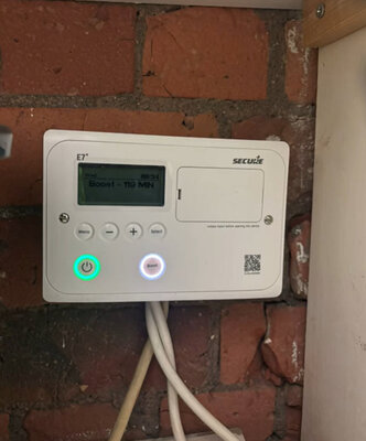 Electric heating controller fitted to an exposed brick wall
