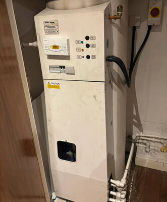 Old floor-standing electric boiler due for replacement in a utility cupboard