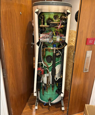 Hot water cylinder opened up showing wiring, valves and immersion connections