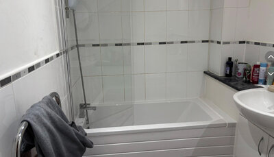 Completed bathroom with new bath, shower screen and tiling