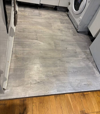 Grey wood-effect vinyl flooring fitted in a utility area