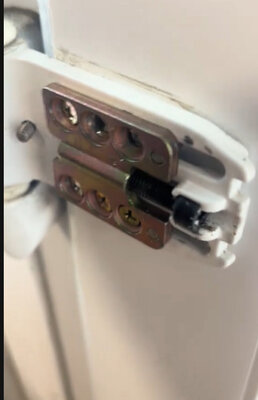 Close-up of a door hinge replaced during carpentry repairs