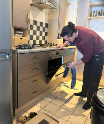 Servicing an oven in a fitted kitchen during a property turnaround