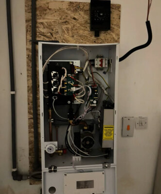 Electric boiler with the cover removed showing internal wiring and components