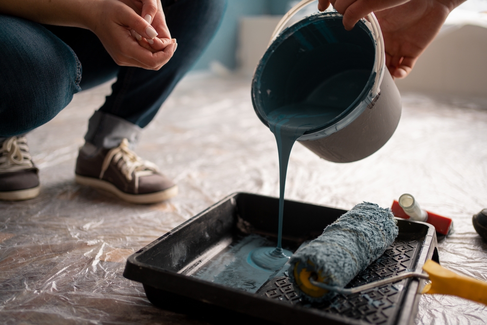 Decorator painting a room during a void property turnaround in Cheshire