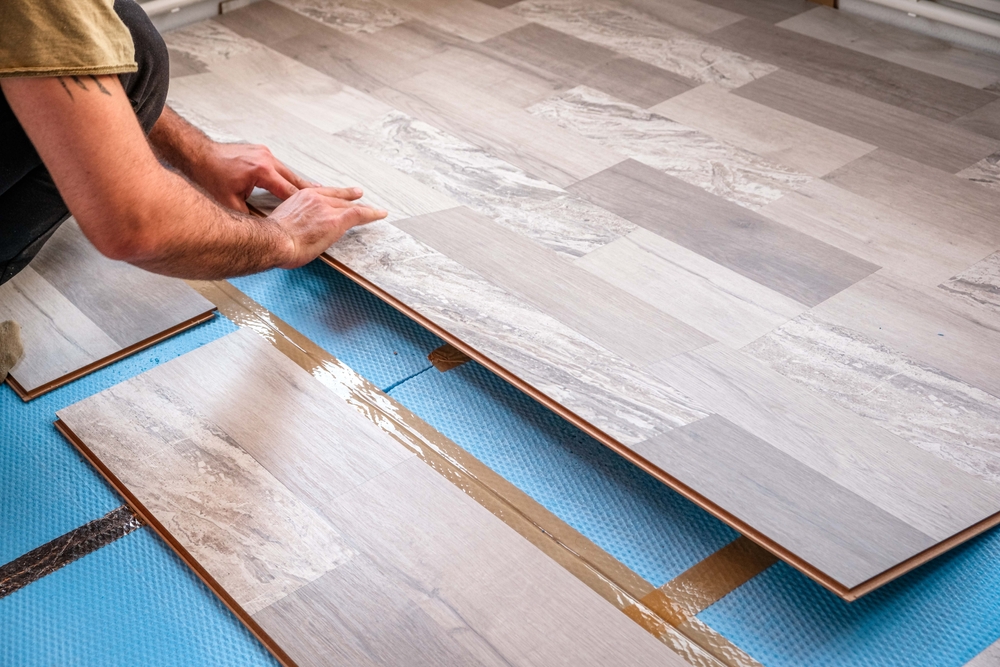 Fitter installing new flooring in a rental property in Cheshire
